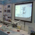 諏訪東京理科大学と諏訪産業集積研究センターの共同出展ブース。ディスプレイ内は壁走行ロボット