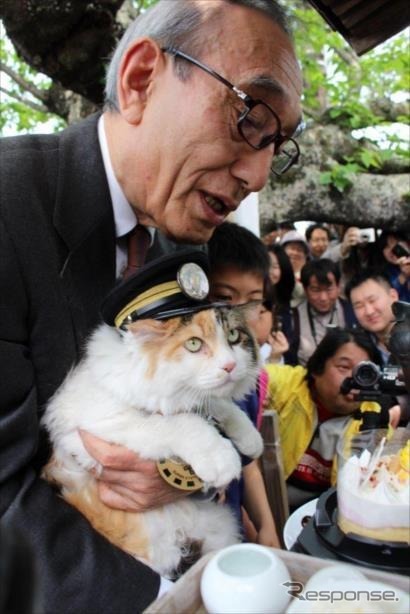 たま神社の前で、和歌山電鉄小嶋光信社長にお世話されるニタマ駅長